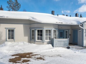 A house with a snow-covered roof, a front porch, and a garage. - Nelikko a by Interhome (Kuusamo)