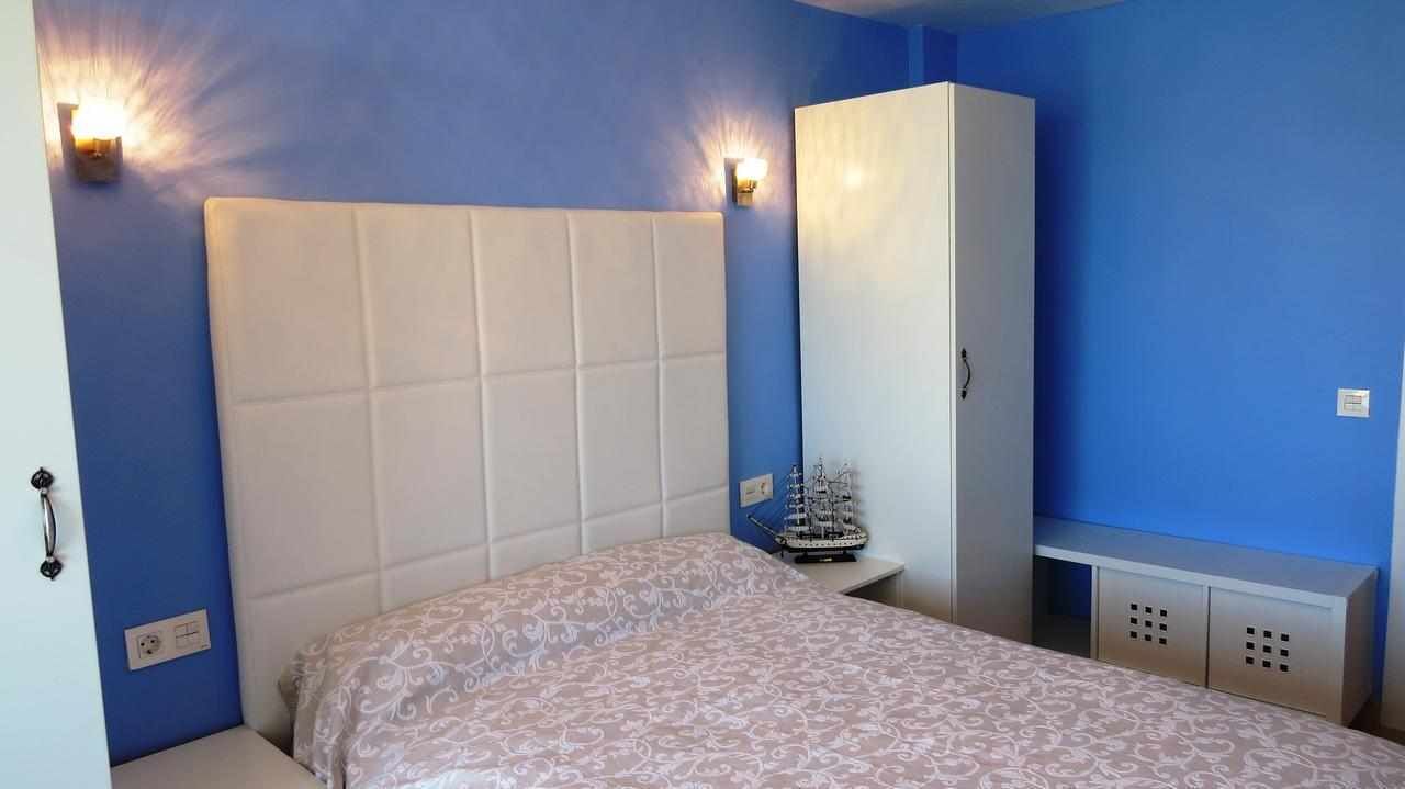 Ein Schlafzimmer mit einem großen Bett, einem Kleiderschrank und zwei Wandleuchten.