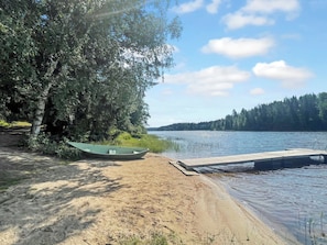A lakeside setting with a dock, a boat, and a tree. - Hellinki by Interhome (Virrat)