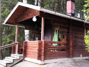 A wooden cabin with a porch, a staircase leading to the entrance, and a chimney. - Hellinki by Interhome (Virrat)