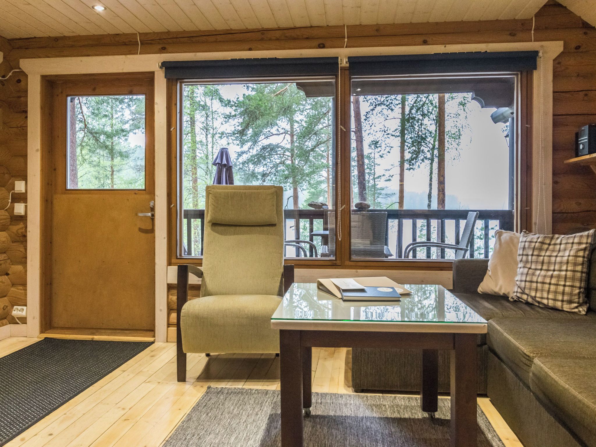 A cozy room with a wooden interior, a sofa, a table, and a chair.