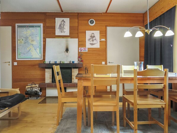 Ein Holzinterieur mit einem Esstisch, Stühlen, einer Karte und einer Wanduhr.