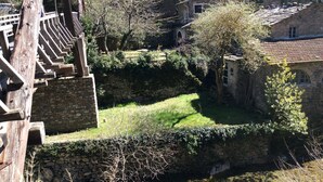 Un bâtiment en pierre doté d’un mur en pierre et d’un petit espace aménagé en jardin.
