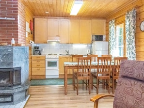 A compact kitchen with wooden cabinets, a stove, a microwave, and a refrigerator.