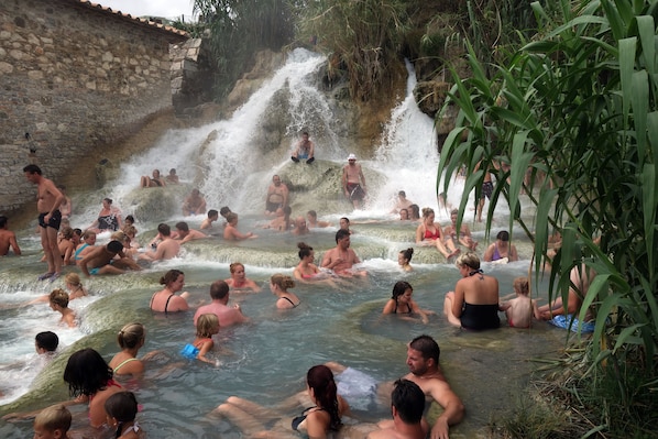A natural hot spring with people relaxing and enjoying the water.