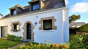 A modern house with a white exterior, stone accents, and a black door.