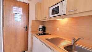 A compact kitchen with a microwave, coffee maker, sink, and dishwasher. - 10m from ski slopes, 1st floor, balcony, 27m², Méribel-Mottaret (Méribel - Les Allues)