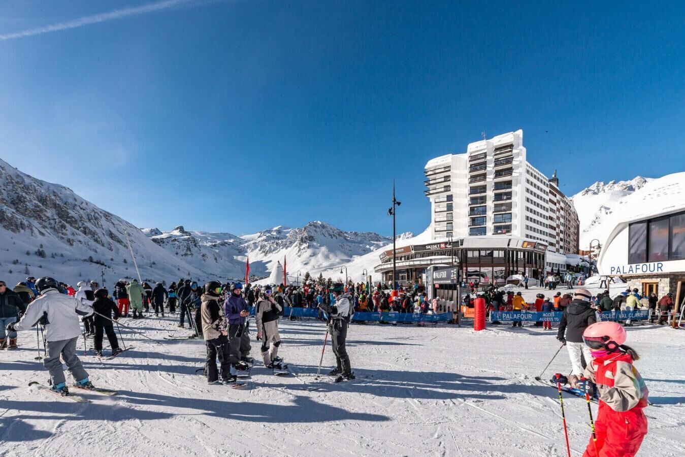 A ski resort with a large building labeled 'Palafox' and a crowd of people on the snow.