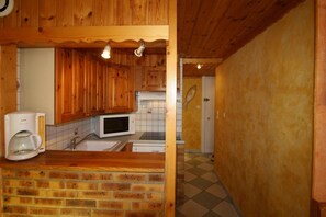 A kitchen with wooden cabinets, a microwave, and a coffee maker.