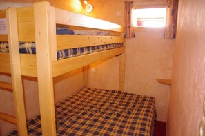 Dormitorio con literas, ventana y una pequeña mesa.