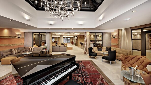 A spacious living area with a grand piano, comfortable seating, and a modern chandelier. - Wifi, 200m from shops, fitness, swimming pool, sauna, hammam, balcony, tv, ski locker, 60m², Samoëns (Samoëns)