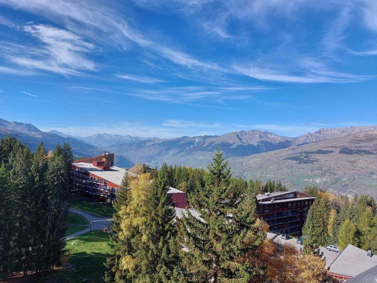 A hotel with multiple buildings, surrounded by dense forest and mountains in the background.