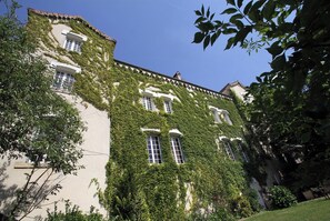 A building with multiple windows and a white facade partially covered by green ivy. - Charming 19th century house with heated swimming pool in Vals les Bains-Ardèche (Ardèche)