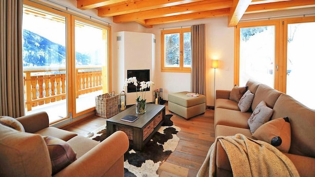 A cozy living room with wooden beams, a sofa, a coffee table, and a fireplace. - Chalet, 250m from ski slopes, balcony, fireplace or stove, parking, tv, 150m², Thyon (Hérémence)