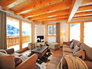 A cozy living room with wooden beams, a sofa, a coffee table, and a fireplace. - Chalet, 250m from ski slopes, balcony, fireplace or stove, parking, tv, 150m², Thyon (Hérémence)