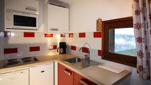 A compact kitchen with a microwave, stove, sink, and Bosch dishwasher. - 150m from ski lifts, 1st floor, balcony, tv, ski locker, 40m², Tignes (Tignes)