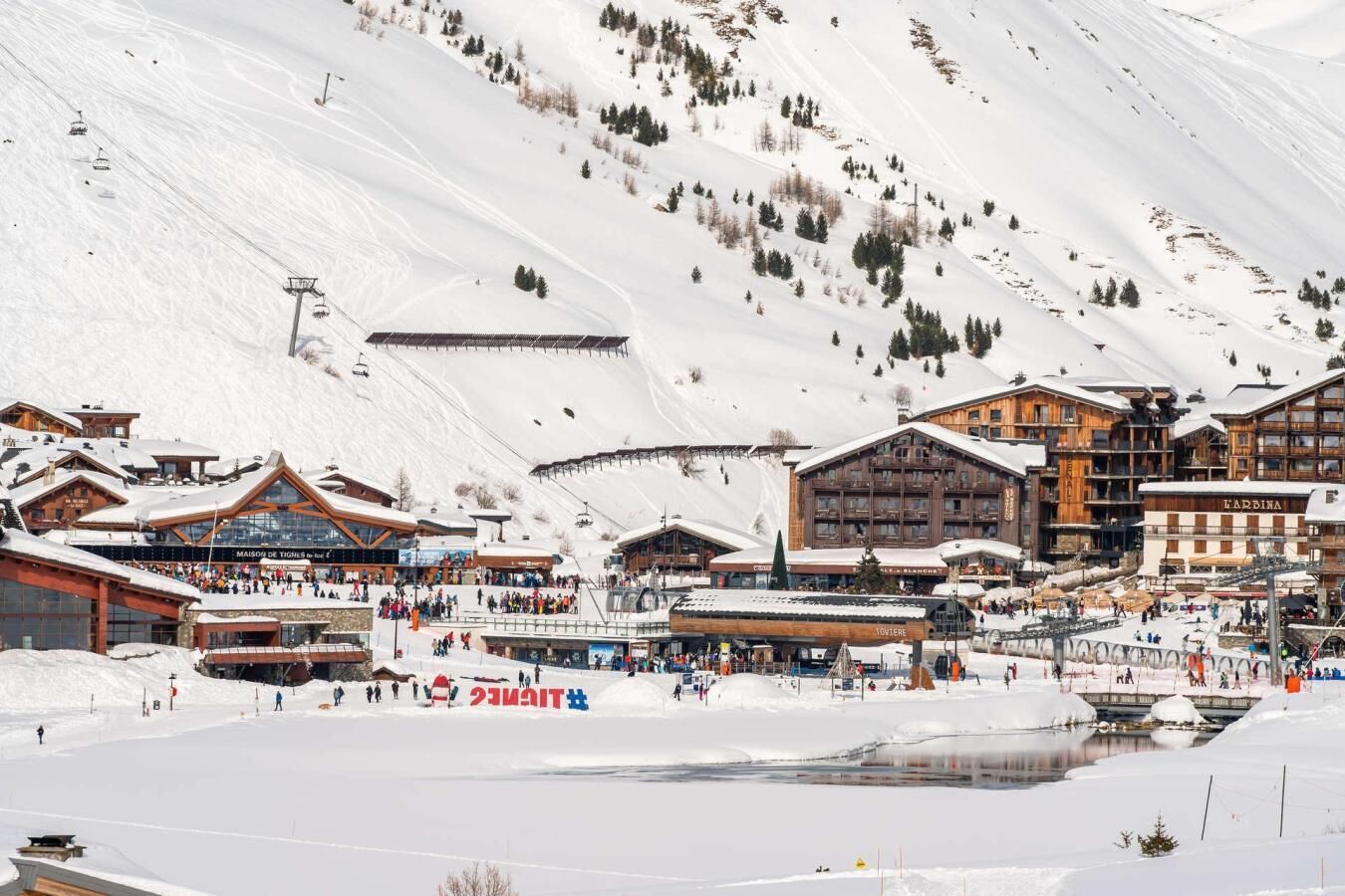 A snow-covered ski resort with multiple buildings, including a large wooden lodge and a restaurant named 'Toviere.'