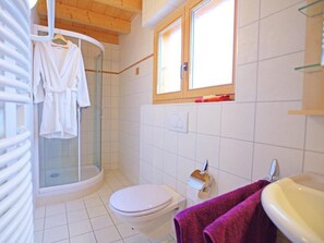 A bathroom with a shower, toilet, and sink.
