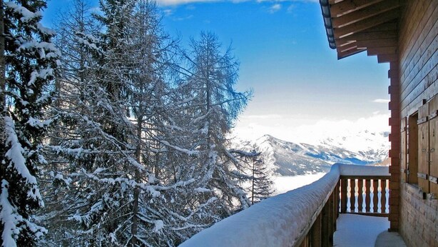 A wooden balcony with snow-covered railings overlooking a snowy forest and mountains. - Chalet, 350m from ski slopes, sauna, terrace, balcony, fireplace or stove, parking, tv, ski locker (La Tzoumaz)