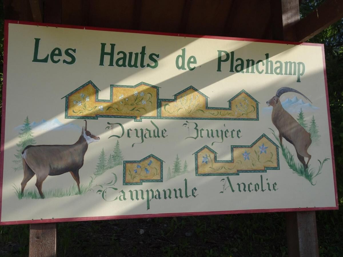 Un letrero con el texto 'Les Hauts de Planchamp' e ilustraciones de un ciervo y un carnero.