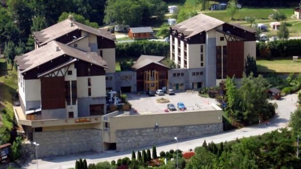Un bâtiment moderne doté d’un toit plat, d’une cour intérieure et d’un espace de stationnement.