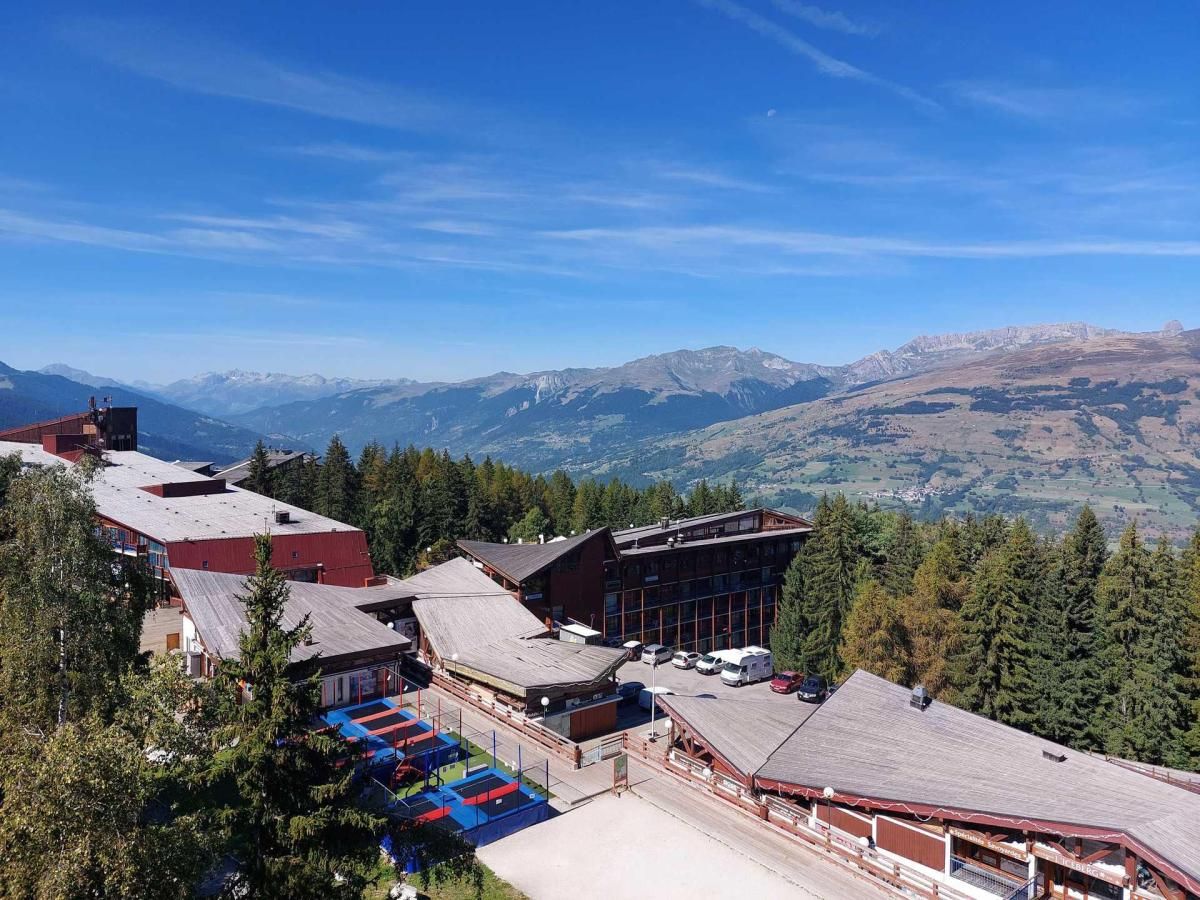 A lodge with multiple buildings, a parking area, and a mountainous backdrop.