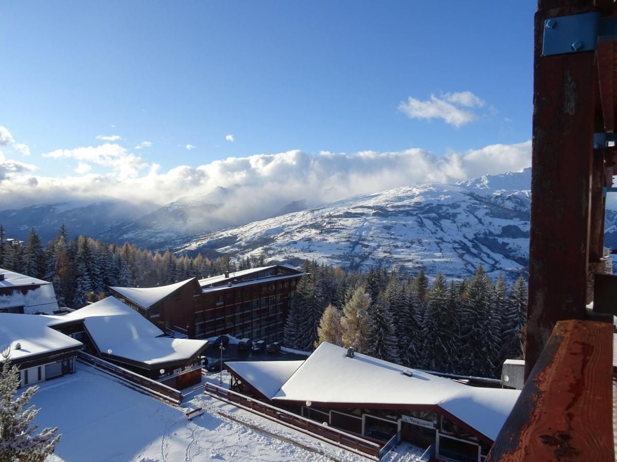 A snow-covered mountain resort with modern buildings and a ski slope.