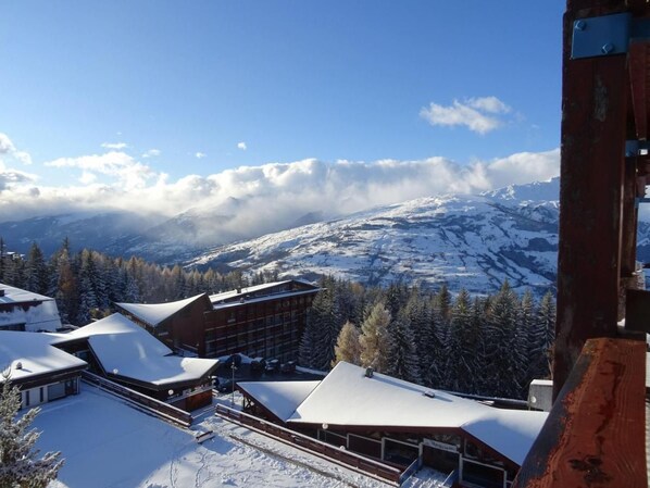 A snow-covered mountain resort with modern buildings and a ski slope.