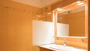 A bathroom with a bathtub, a sink, and a mirror. - 10m from ski slopes, 1st floor, balcony, tv, ski locker, 42m², Val Cenis (Lanslevillard)