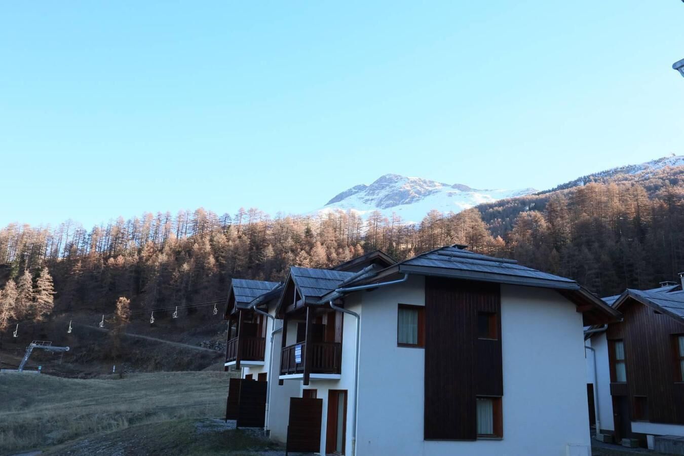 A row of cabins with a mountain in the background.