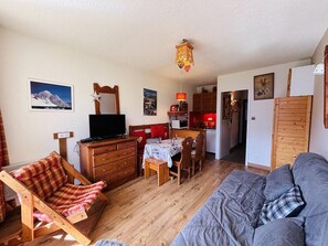 A cozy living room with a sofa, a wooden chair, a dining table, and a television. - 350m from ski slopes, 4th floor, view mountain, balcony, tv, ski locker, 24m², Peisey-Vallandry (Peisey-Nancroix)