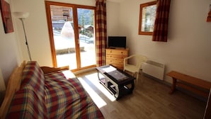 A room with a bed, a desk, a chair, a dresser, and a television. - 300m from ski slopes, floor -1, view mountain, terrace, parking, tv, ski locker, 49m², Valfréjus (Valfréjus)