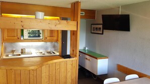 Cocina compacta con armarios de madera, pileta integrada y una pequeña encimera.