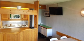 A compact kitchen with wooden cabinets, a built-in sink, and a small countertop.