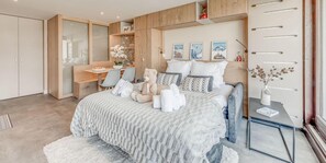 Ein Schlafzimmer mit einem Bett, Nachttischen, einem Schreibtisch und einem Kleiderschrank.