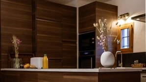 A modern kitchen with wooden cabinets, a white countertop, and a vase with flowers. - 300m from ski lifts, fitness, sauna, hammam, terrace, fireplace or stove, ski locker, 126m² (Valloire)