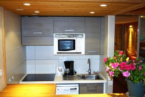 A compact kitchen with a built-in microwave, a coffee maker, and a sink.