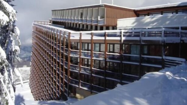 Un edificio moderno con fachada de vidrio y estructura de madera.