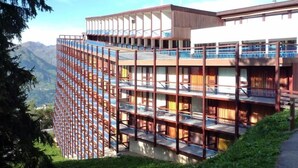 Un hotel de varios pisos con balcones y vistas a las montañas.