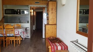 A cozy kitchen with wooden cabinets, a dining table with chairs, and a small seating area with a bench. - 100m from ski slopes, 2nd floor, view valley, balcony, tv, 30m², Les Arcs (Les Arcs)
