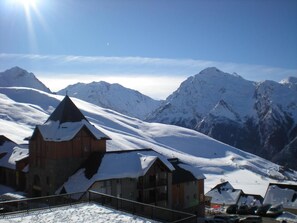 A snow-covered mountain with a wooden building featuring a steep roof and a stone archway. - Wifi, fitness, swimming pool, sauna, ski locker, 25-27m², Peyragudes (Germ)