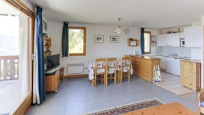A cozy, well-lit room with a dining area, kitchen, and a large window providing natural light. - 150m from ski slopes, 1st floor, terrace, tv, 75m², Peisey-Vallandry (Landry)