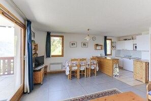 A cozy, well-lit room with a dining area, kitchen, and a large window providing natural light. - 200m from resort center, 1st floor, terrace, tv, 75m², Peisey-Vallandry (Landry)