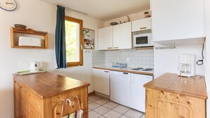 A compact kitchen with white cabinets, a microwave, a coffee maker, and a wooden table. - 150m from ski slopes, 1st floor, terrace, tv, 75m², Peisey-Vallandry (Landry)