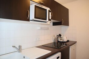 A compact kitchenette with a microwave, stove, sink, and a coffee maker. - Ski-in/ski-out & foot of the slopes, 2nd floor, view swimming pool, swimming pool, sauna, hammam (Les Orres)