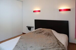 A bedroom with a bed, a nightstand, and two wall-mounted light fixtures. - Ski-in/ski-out & foot of the slopes, 2nd floor, view swimming pool, swimming pool, sauna, hammam (Les Orres)