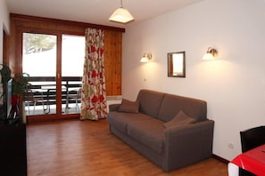 A living room with a sofa, a table, and a plant. - Ski-in/ski-out & foot of the slopes, 2nd floor, view swimming pool, swimming pool, sauna, hammam (Les Orres)