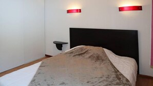 Ein Schlafzimmer mit einem Bett, einem Nachttisch und zwei Wandleuchten.