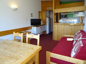 A compact room with a wooden dining table, a sofa, a television, a refrigerator, and a kitchenette with a microwave. - Ski-in/ski-out & foot of the slopes, 16th floor, view resort, tv, 29m², Les Arcs (Les Arcs)