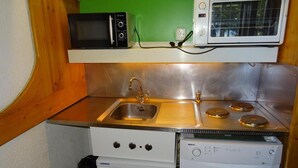 Una kitchenette compacta con lavamanos, estufa, microondas y lavavajillas.